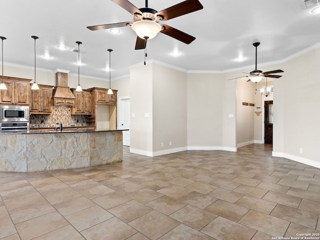 kitchen featuring brown cabinetry, decorative backsplash, ornamental molding, custom exhaust hood, and stainless steel appliances
