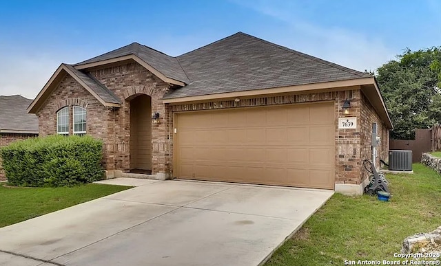 view of front facade featuring a garage, concrete driveway, cooling unit, and brick siding