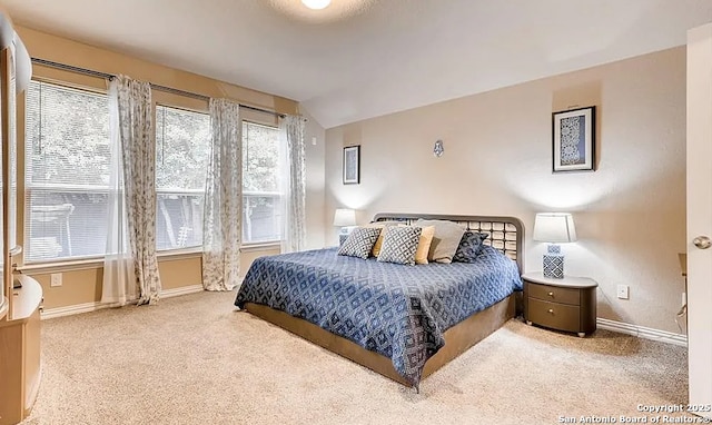 bedroom featuring carpet, baseboards, and vaulted ceiling