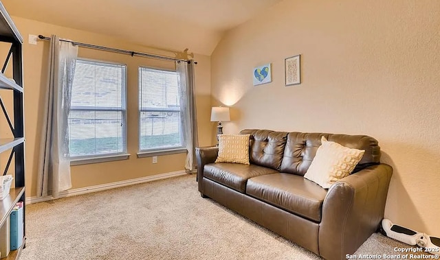 living area with light carpet, baseboards, and lofted ceiling