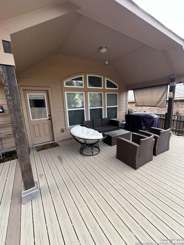 wooden terrace featuring a grill and an outdoor living space