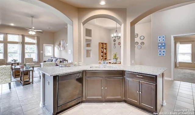 kitchen featuring a sink, black dishwasher, dark brown cabinets, open floor plan, and decorative light fixtures