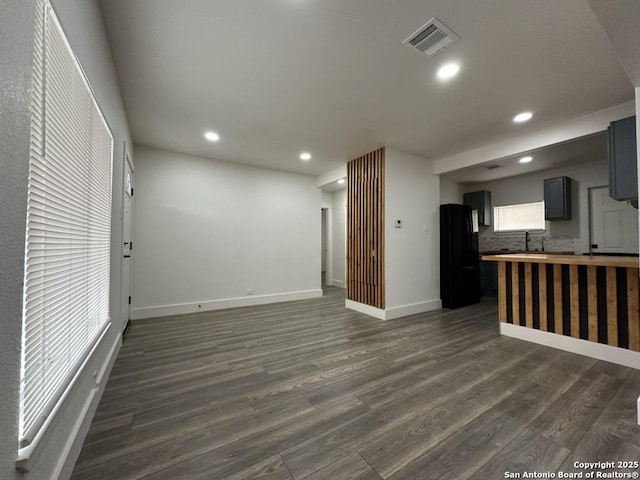 kitchen with recessed lighting, visible vents, gray cabinets, freestanding refrigerator, and dark wood-style floors