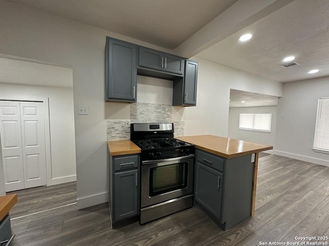 kitchen with wooden counters, stainless steel gas range oven, a peninsula, and gray cabinets