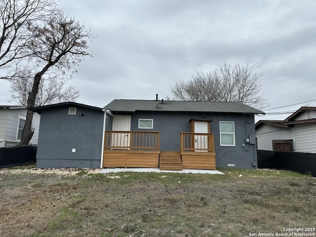 back of property featuring crawl space, a wooden deck, a lawn, and stucco siding