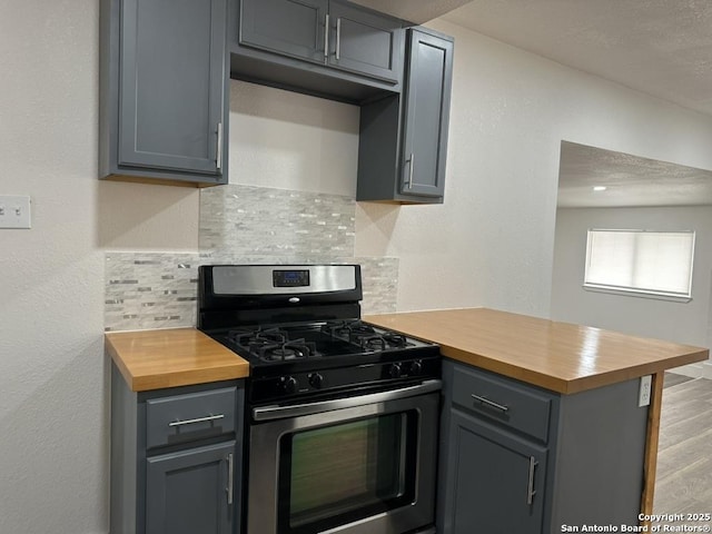 kitchen featuring gas stove, wood counters, and gray cabinetry