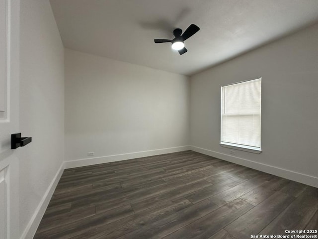 spare room with ceiling fan, baseboards, and dark wood-style flooring