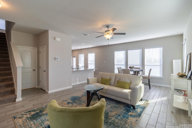 11830 Bricewood Pass, San Antonio, TX 78254 - living room with ceiling fan, wood finish floors, visible vents, baseboards, and stairway