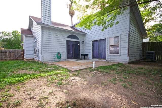 rear view of property with a patio area, fence, a chimney, and central air condition unit