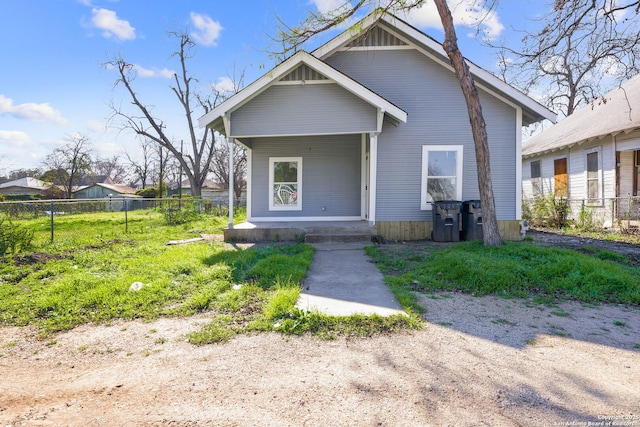 bungalow-style house with covered porch and fence