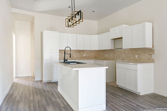 kitchen with a sink, a center island with sink, and white cabinets