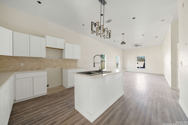 kitchen featuring white cabinets, ceiling fan, wood finished floors, a kitchen island with sink, and a sink