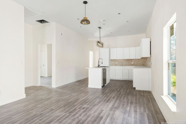 kitchen featuring a kitchen island with sink, a sink, white cabinetry, light countertops, and dishwasher