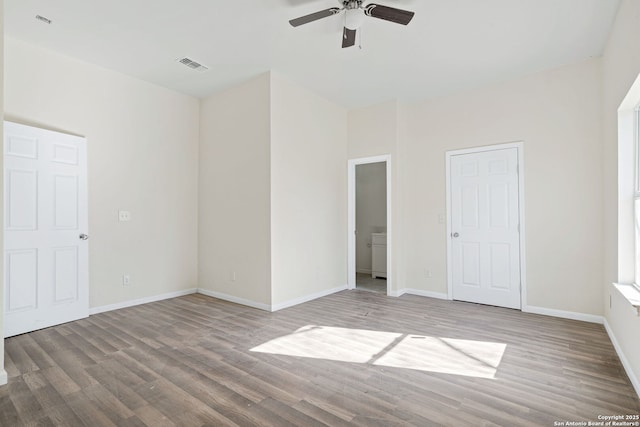 unfurnished bedroom featuring baseboards, visible vents, and wood finished floors