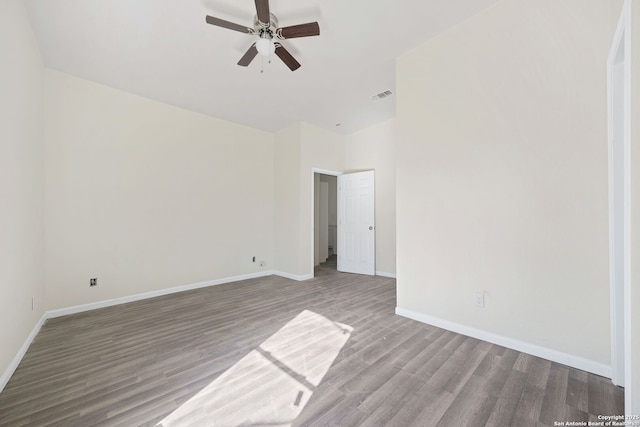 unfurnished room with a ceiling fan, baseboards, visible vents, and wood finished floors