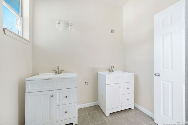 bathroom with two vanities, a sink, baseboards, and tile patterned floors