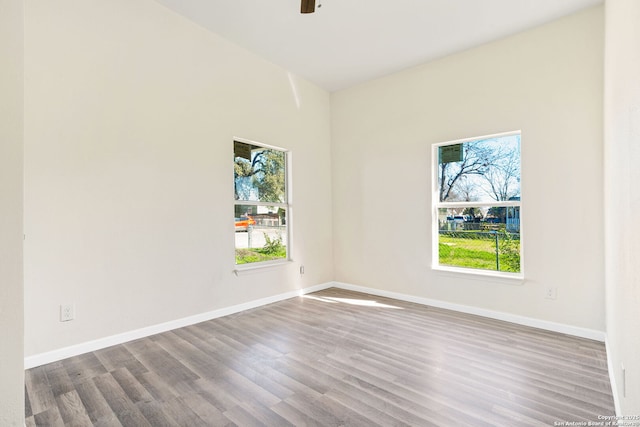 unfurnished room with baseboards and wood finished floors