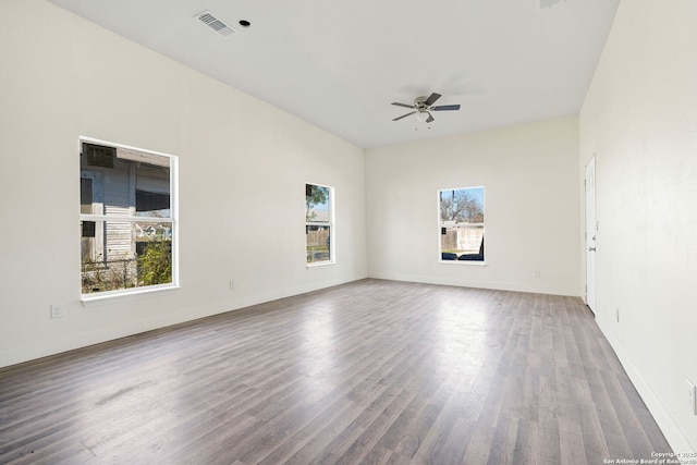 unfurnished room with baseboards, ceiling fan, visible vents, and wood finished floors