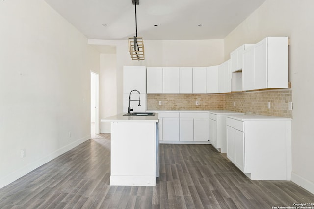 kitchen featuring white cabinets, light countertops, and a sink