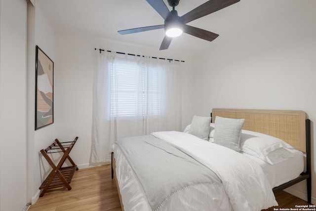 bedroom with ceiling fan, light wood-type flooring, and baseboards