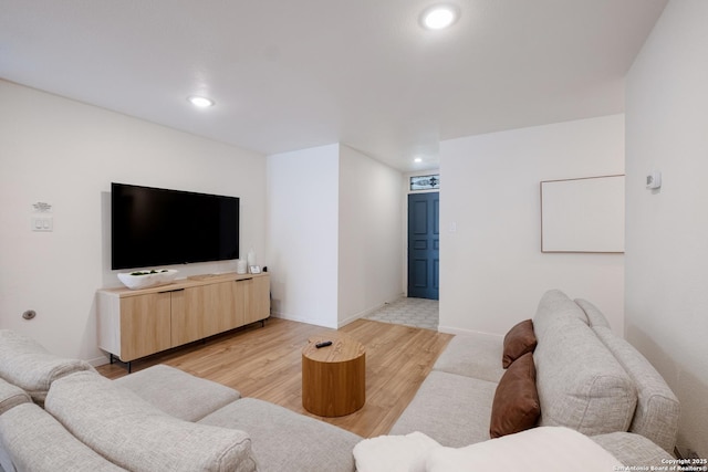 living room featuring baseboards, light wood finished floors, and recessed lighting