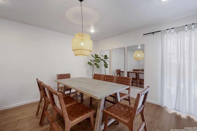 dining space featuring baseboards and wood finished floors