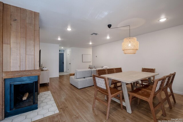 dining space with recessed lighting, a fireplace, visible vents, baseboards, and light wood-style floors