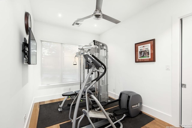 exercise area featuring ceiling fan, wood finished floors, visible vents, and baseboards