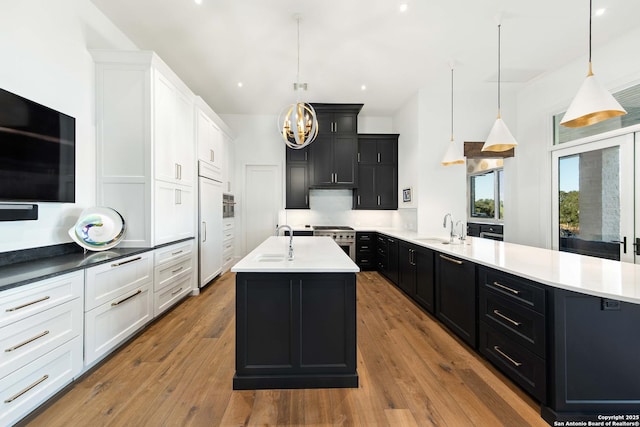 kitchen with dark cabinetry, high end appliances, and a sink