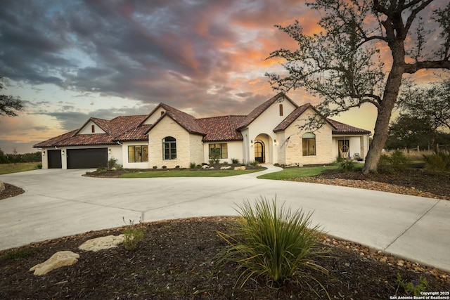 view of front of home with driveway and a tile roof