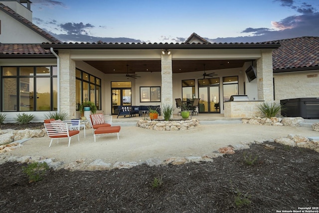 rear view of property with a tile roof, ceiling fan, and a patio