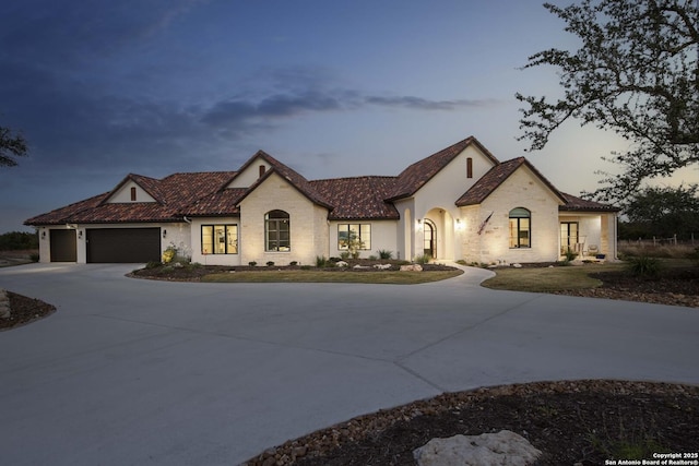 view of front of property featuring an attached garage, concrete driveway, and stucco siding