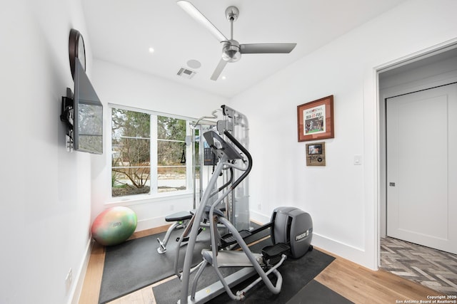 exercise area featuring baseboards, ceiling fan, visible vents, and light wood-style floors