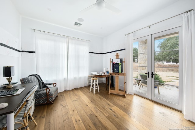 office with hardwood / wood-style flooring, ceiling fan, visible vents, and french doors