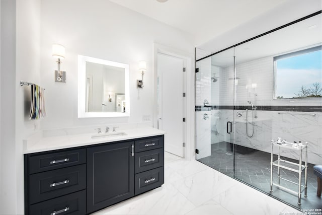 bathroom with marble finish floor, a shower stall, and vanity