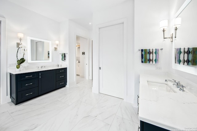 bathroom featuring marble finish floor, two vanities, and a sink