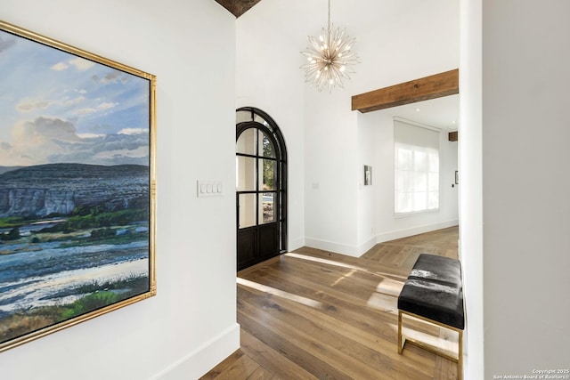 entrance foyer with an inviting chandelier, baseboards, and wood finished floors