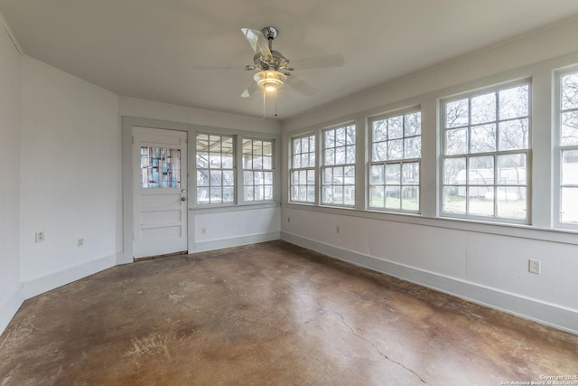 unfurnished sunroom with a ceiling fan and a healthy amount of sunlight