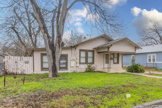 view of front of property with fence and a front lawn