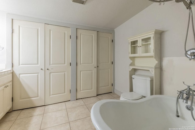 bathroom featuring a closet, toilet, a textured ceiling, vanity, and tile patterned floors