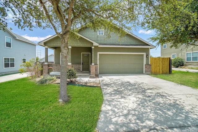 craftsman-style home featuring an attached garage, driveway, fence, and a front lawn