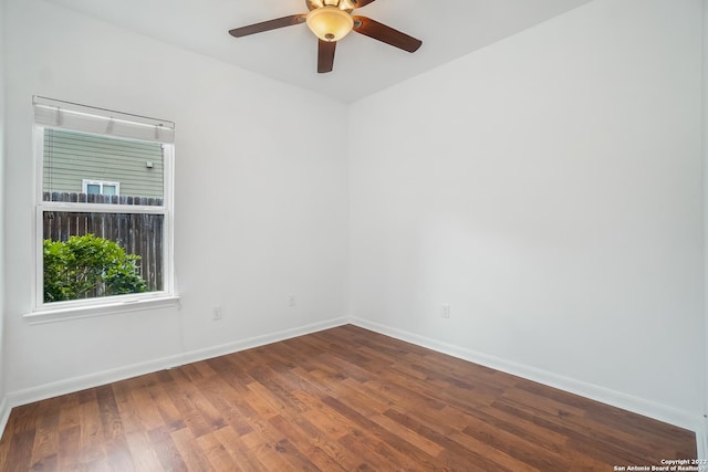 empty room featuring a ceiling fan, baseboards, and wood finished floors