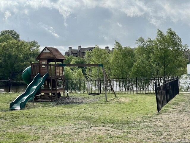 view of jungle gym with a yard and fence