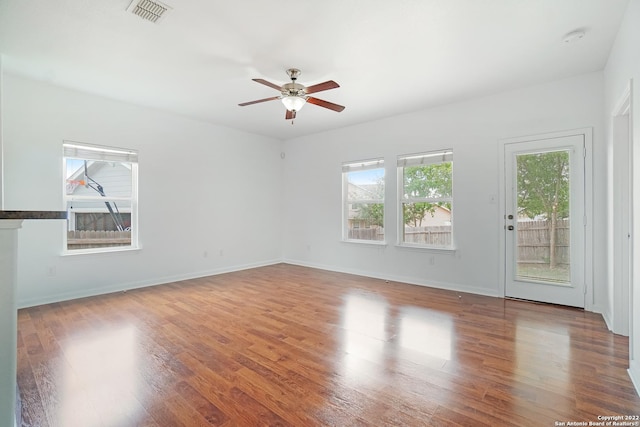 unfurnished room with visible vents, ceiling fan, baseboards, and wood finished floors