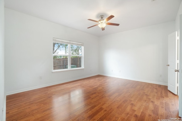 spare room featuring ceiling fan, wood finished floors, and baseboards