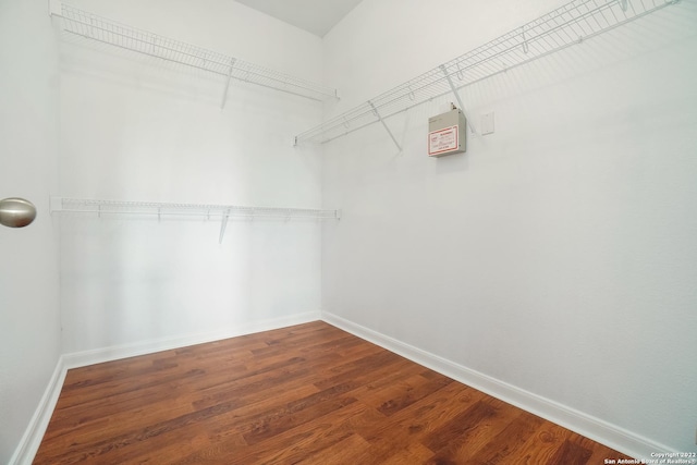 walk in closet with wood finished floors