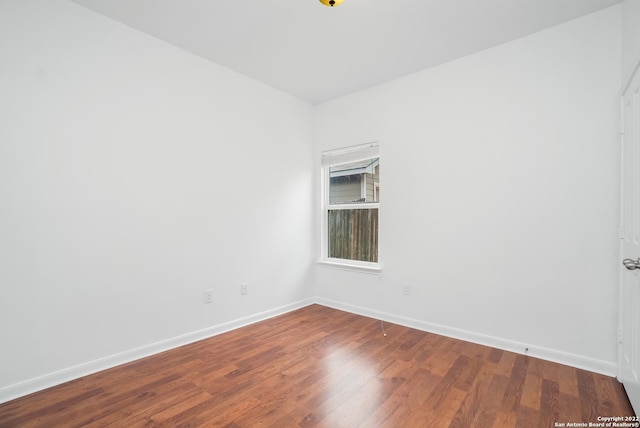 unfurnished room with baseboards and wood finished floors