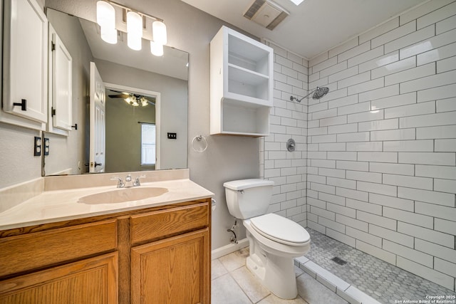 bathroom featuring ceiling fan, tile patterned flooring, toilet, vanity, and a stall shower