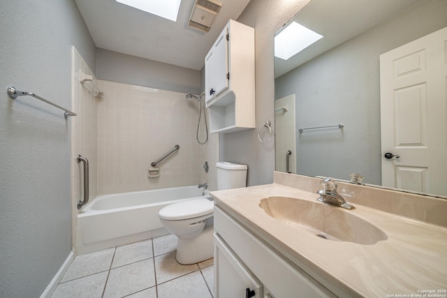 bathroom with tile patterned flooring, toilet, a skylight, vanity, and bathing tub / shower combination