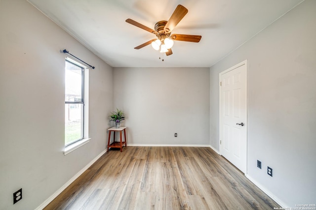 unfurnished room with ceiling fan, wood finished floors, and baseboards